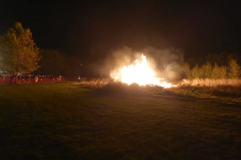 The bonfire alight at Rawcliffe Bar Country Park with a crowd behind the barriers
